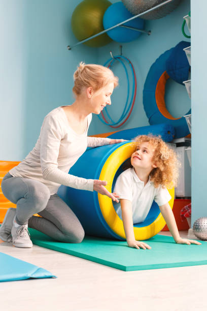 small kid getting sensory therapy from a woman therapist